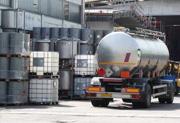 Barcelona, Spain - July 11, 2024: Sunrise over Bunge Iberica tanks and silos on Coma I Ribas Port Terminal. Docked red bunker boat.